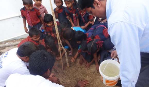 Employees planted saplings along with children