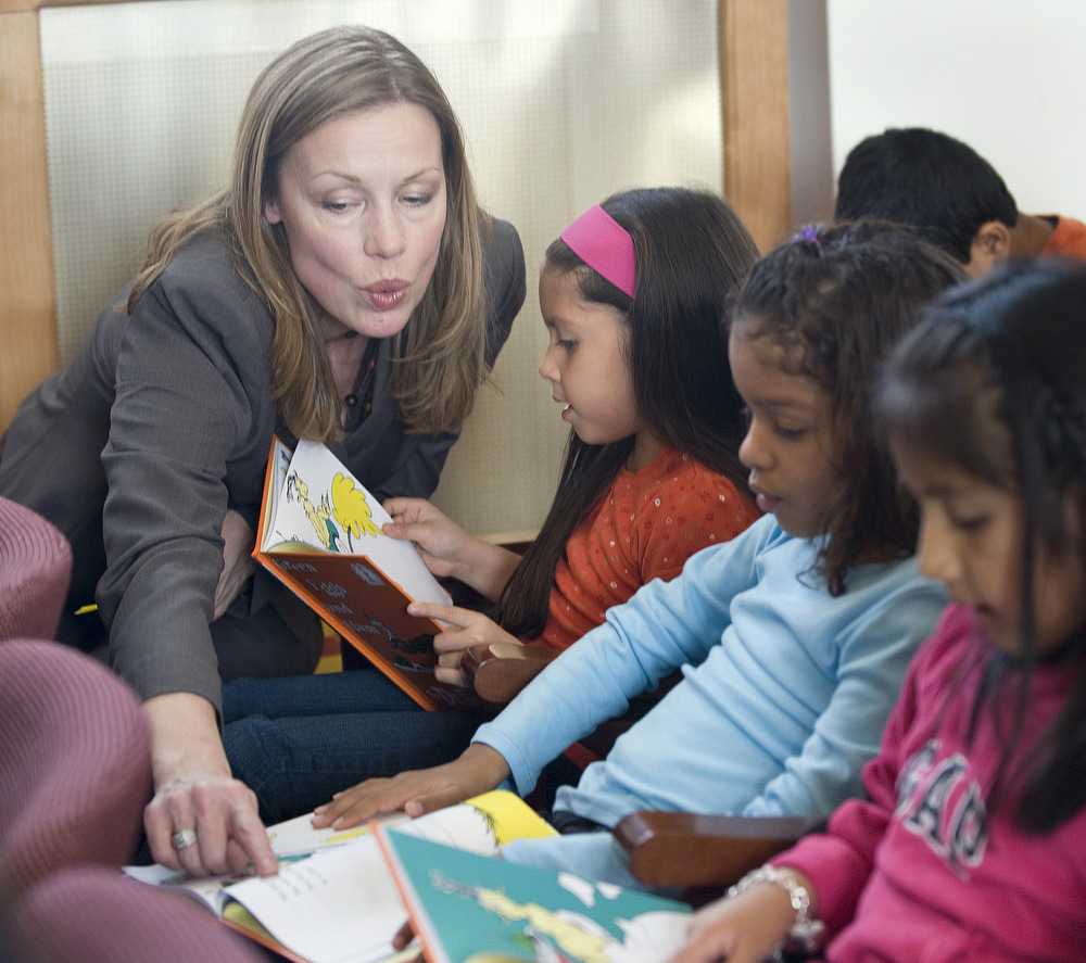 left to right Joan Sahlgren, the Vice President of Communications for First Book reads 'Green Eggs and Ham' with first-graders Darel Barrera and Kimberly Grullon-Diaz. The Jackson Avenue Elementary School hosted volunteers from Jaguar/Land Rover North America, Tata Sons, Ltd and First Book to kick off a donation of 10,00 books across New Jersey. Hackensack,NJ 10/26/09 1:53:48 PM photo by Joe Epstein